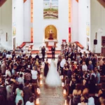 Brautmutter führ Braut zum Bräutigam in der Kirche, Gäste stehend, Bild von oben, indoor