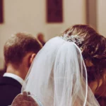 Kopf von Braut und Bräutigam von hinten während Trauzeremonie, indoor