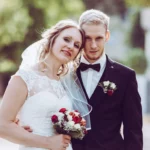 Paarshooting, Bräutigam hält Braut im Arm Hochzeitsstrauß Gegenlicht Brustbild outdoor