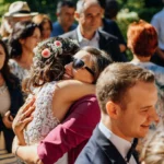 Braut wird von Freundin in der Menge gedrückt und beglückwünscht Brustbild outdoor