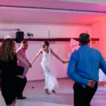 Hochzeitsfeier, Braut tanzt im Kreis mit Gästen indoor