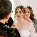 Getting-Ready Shooting, Braut beim Halskette anlegen mit Helfern Brustbild indoor