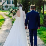 Paarshooting, Braut und Bräutigam von hinten Ganzkörper Hand in Hand Hochzeitsstrauß outdoor