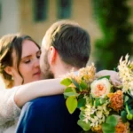 Paarshooting, Kussszene Braut und Bräutigam Brustbild Fokus Hochzeitsstrauß outdoor